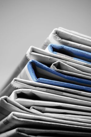 Folded newspapers on brown wooden table