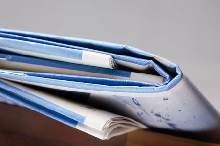 Folded newspapers on brown wooden table