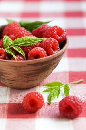 Fresh raspberries in brown bowl, shallow focus