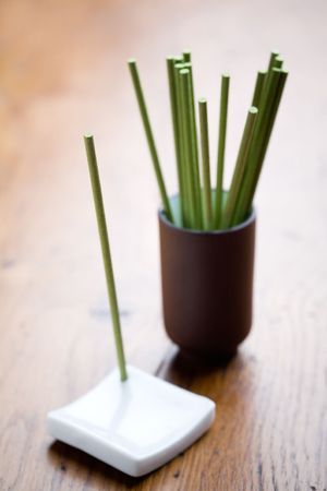 Green incense sticks on brown wooden tableの写真素材