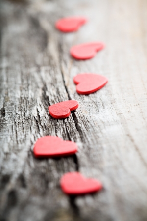 Little red hearts on old wooden backgroundの写真素材