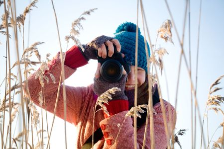 Young pretty woman taking nature pictures outdoorsの写真素材