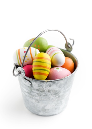 Colorful easter eggs in bucket, isolated on whiteの写真素材