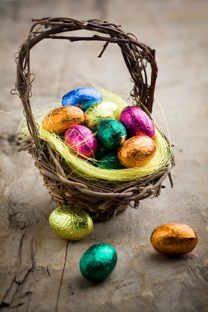 Colorful chocolate easter eggs in brown basketの写真素材