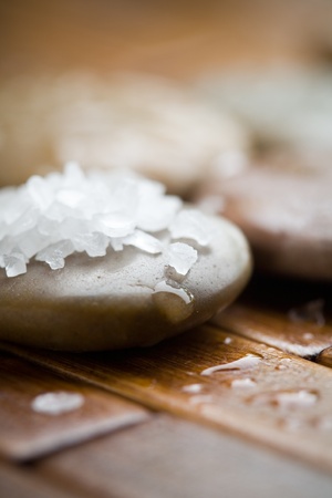Close up of white bath salt on brown stoneの写真素材