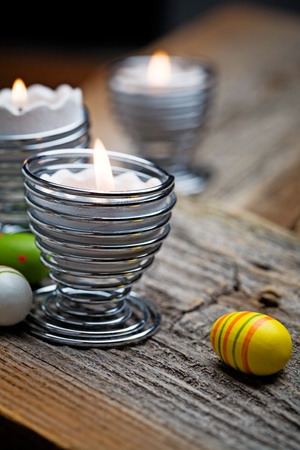 Easter candles on wooden table with egg decorationsの写真素材