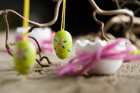 Easter candles on wooden table with egg decorations