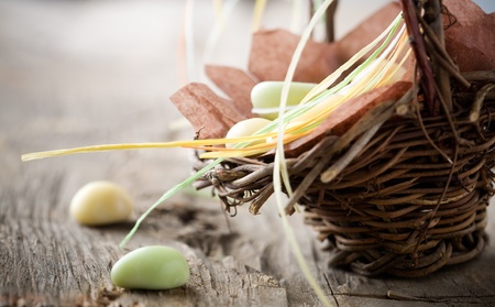 Colorful easter candy in brown basket with ribbon