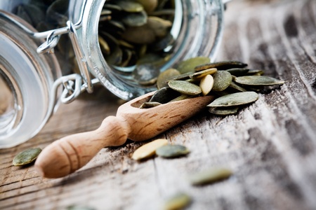 pumpkin seeds in small glass jar with selective focusの写真素材