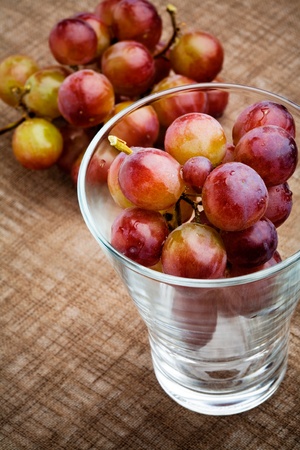 Fresh red grapes on brown table clothの写真素材