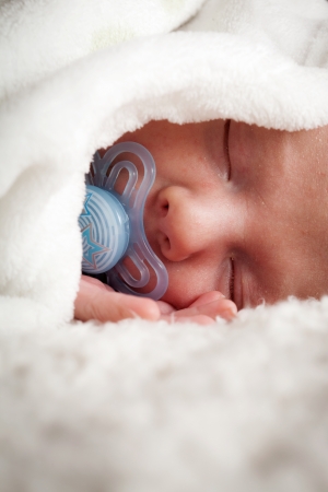 Newborn baby boy sleeping on white blanketの写真素材