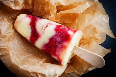 Homemade popsicles with vanilla pudding and raspberriesの写真素材