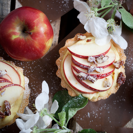 Tartlets with apple slices, cream and pecan fillingの写真素材