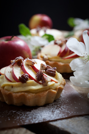Tartlets with apple slices, cream and pecan fillingの写真素材