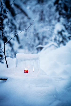 Ice lantern with red candle burning insideの写真素材