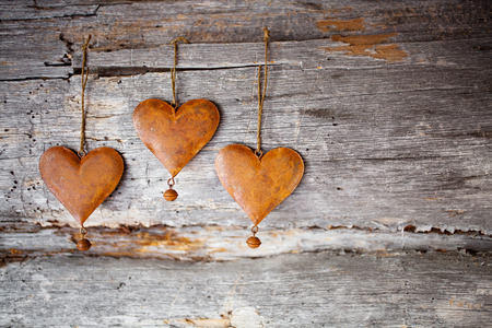 Rustic hearts hanging against weathered woodの写真素材