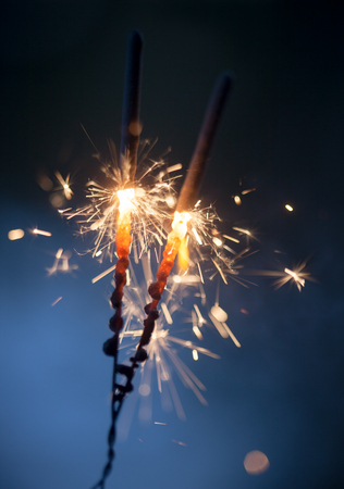 Sparkler burning and glowing in the darkの写真素材