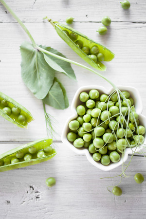 Fresh green peas on white tableの写真素材