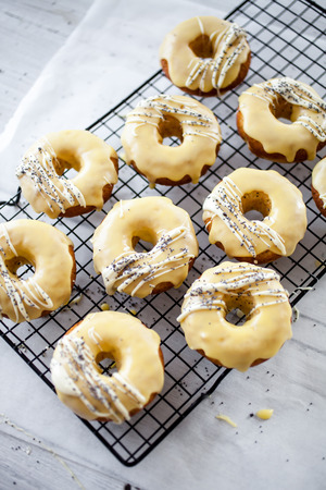 Lemon donuts with white chocolate and poppy seedsの写真素材