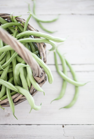 Group of green beans on white wooden table background