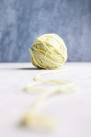 Closeâ€‘up photograph of multicolored yarn ball on a soft, textured background. The shallow...