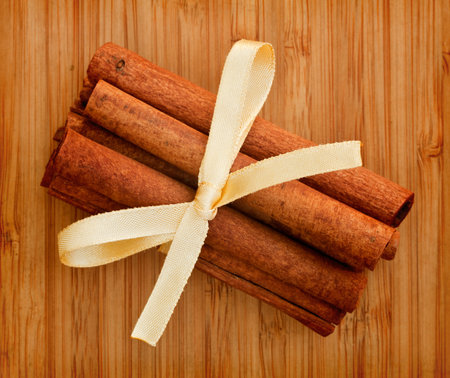 cinnamon sticks with a bow on a bamboo board