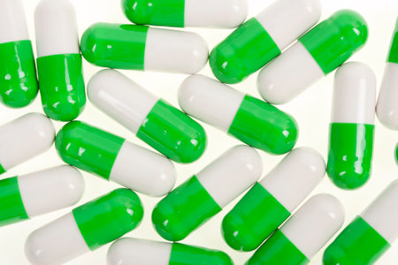 Close up of green and white capsules isolated on a white background.の写真素材