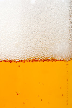 Close up of beer in a glass with foam. Beer background.の写真素材