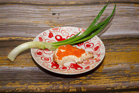 Red salmon caviar in a spoon with a sandwichの写真素材