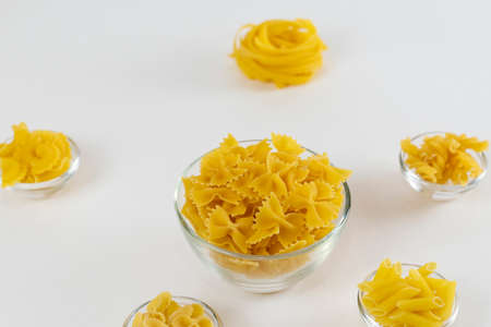 Various types of pasta speread out in piles on white. Cooking concept. Layout of raw pasta.の写真素材