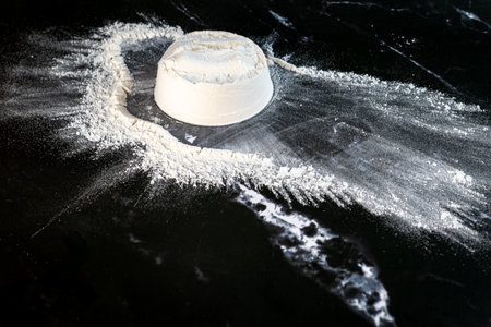 White flour on a black background with a rolling pin. Toned.の写真素材