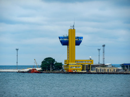 Cargo terminal for loading bulk cargo of iron ore by ship cranes and grabs. View from the sea....