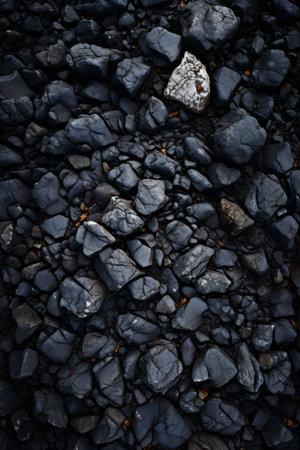 Close-up of dark gray and black rocks with a single white rockの素材