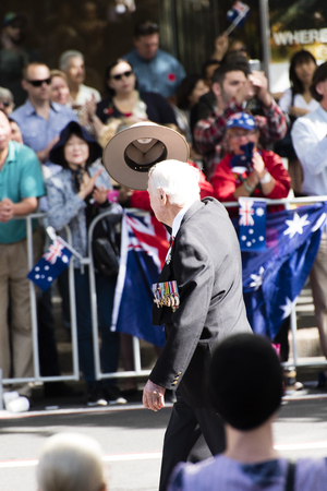 Veteran taking his hat off to the crowd while marching down Elizabeth Stのeditorial素材
