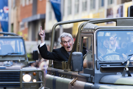 Veteran in an open army jeep talks to the crowd as he moves down Elizabeth Stのeditorial素材