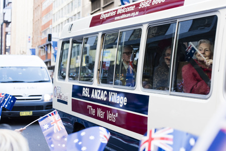 RSL ANZAC Village bus carrying veterans and their families smile as the pass the crowdのeditorial素材