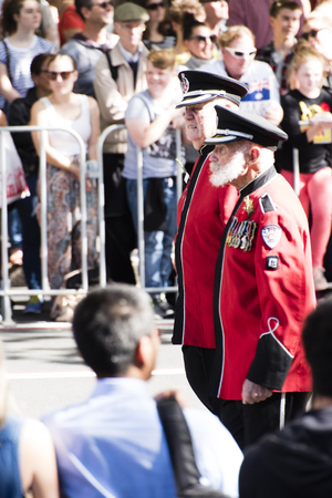 Ex-servicemen from the NSW Firefighters unit marching down Elizabeth St Sydney wearing red uniformsのeditorial素材