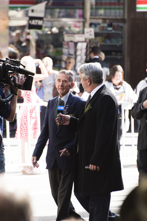 Channel nine reporter interviewing a veteran walking as they move down Elizabeth Stのeditorial素材