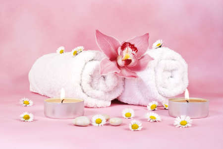 two towels with a pink orchid and two candelsの写真素材