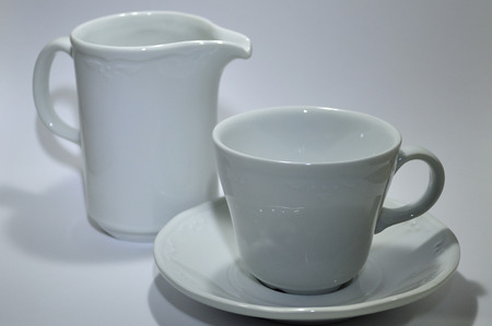 Coffee cup and white porcelain milk jugの写真素材