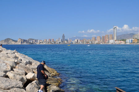 Person going down the cliff overlooking Benidorm, Alicante, Spainの写真素材