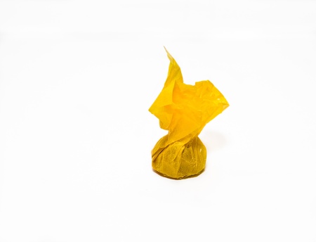 Toffee in yellow wrapper on white background