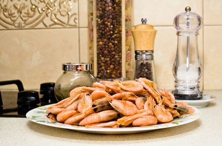 The plate full of prawns against the background of pepper shaker and salt shakerの写真素材