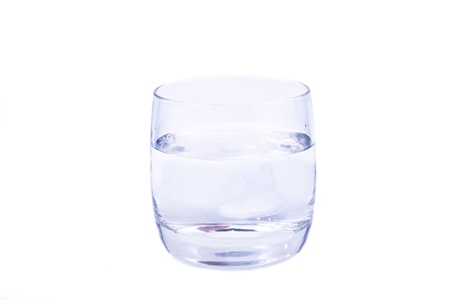 aspirin dissolving in the glass of water isolated over white backgroundの写真素材