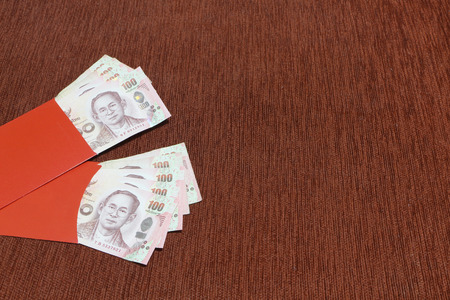 Two red envelope with thai baht bank as Chinese new year gift "angpao". Holiday and finance concept.の写真素材