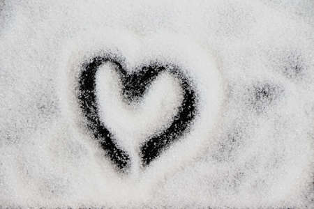 Heart shape on white sugar on black background. Hand drawn symbol of love for valentine's day.の写真素材