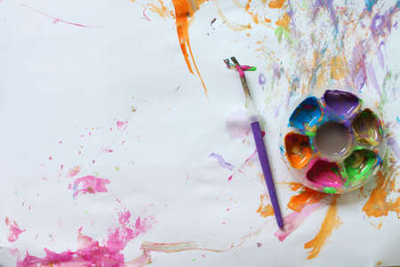 Watercolor in palette and brushstrokes on white paper background. Top view.の写真素材