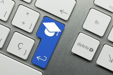 Graduation Written on Blue Key of Metallic Keyboard. Finger pressing key.の写真素材