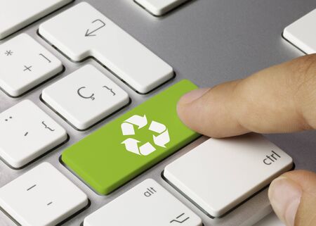 Recycle Written on Green Key of Metallic Keyboard. Finger pressing key.の写真素材