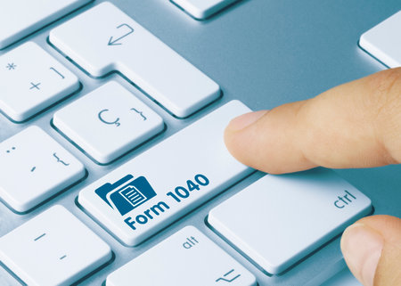 Form 1040 Written on Blue Key of Metallic Keyboard. Finger pressing key.